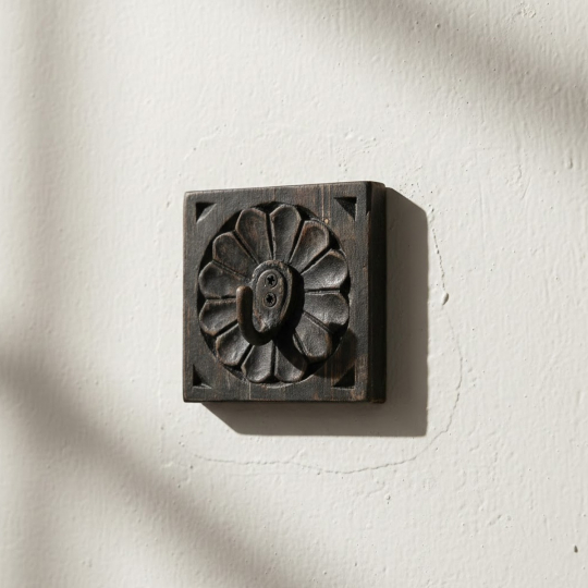 Front view of Tavr wooden wall hook black square wooden base with carved floral pattern and iron hook