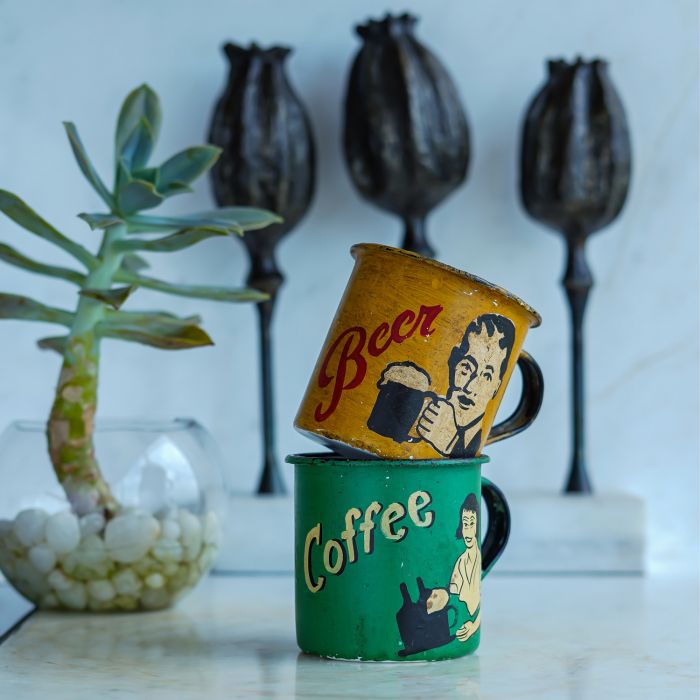 Painted vintage enamel mugs in yellow and green with retro handcrafted appeal